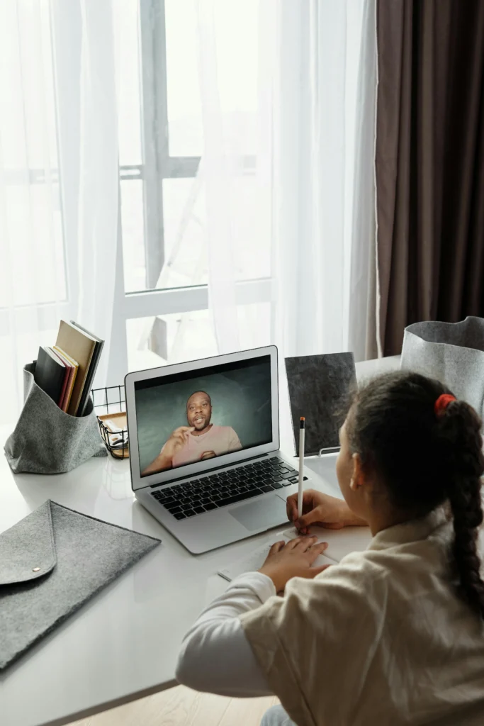 Una bambina prende appunti durante una video lezione.